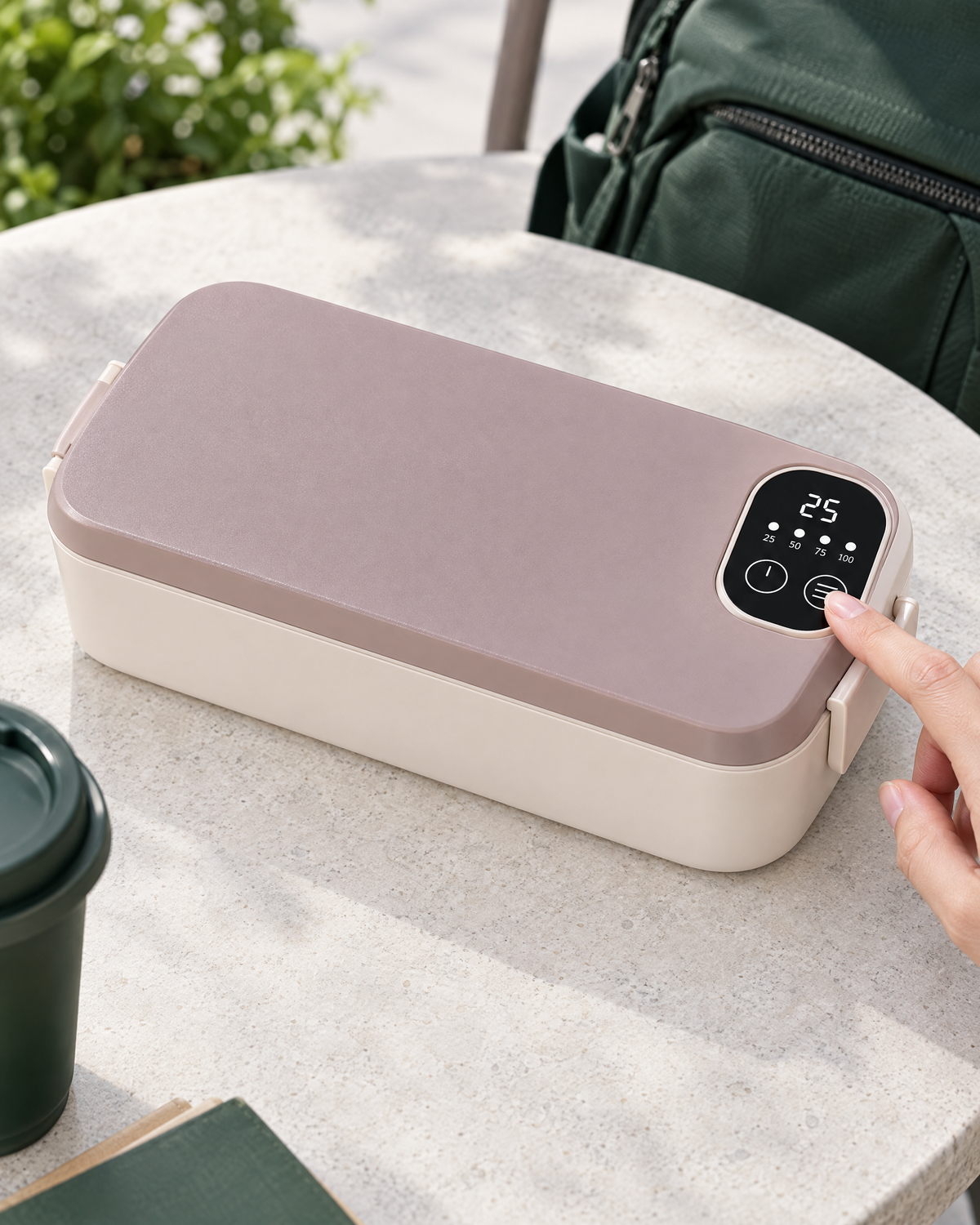 A hand using the temperature mode control on the rechargeable NOONKIND Go lunch box